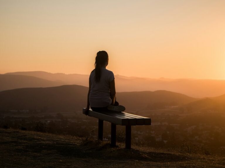 Person meditating at sunset