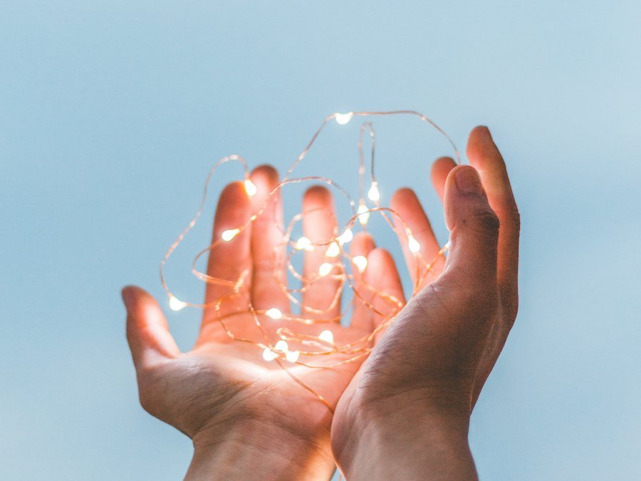 Hands holding glowing light
